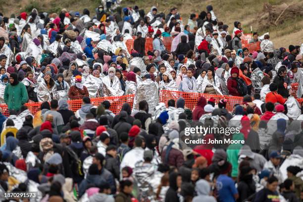 Immigrants wait to be processed at a U.S. Border Patrol transit center after they crossed the border from Mexico on December 20, 2023 in Eagle Pass,...