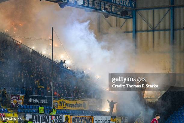 Supporters of Dresden fire smoke bombs during the 3. Liga match between Arminia Bielefeld and Dynamo Dresden at Schueco Arena on December 20, 2023 in...