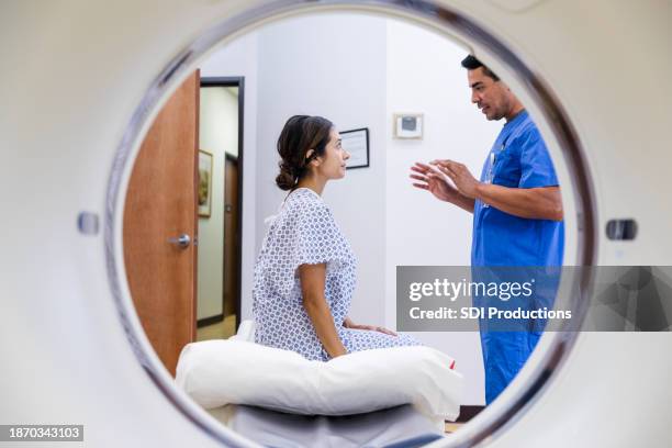 male radiographer talks with attentive female patient - medische röntgenfoto stockfoto's en -beelden