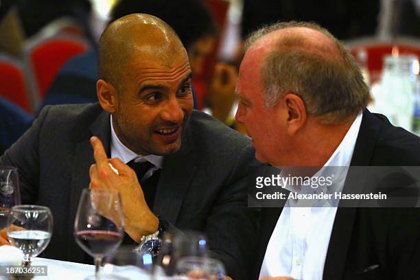 Pep Guardiola, head coach of FC Bayern Muenchen talks to Uli Hoeness , President of Bayern Muenchen during the Champions Dinner night after winning...