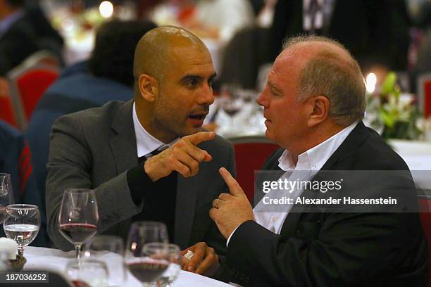 Pep Guardiola, head coach of FC Bayern Muenchen talks to Uli Hoeness , President of Bayern Muenchen during the Champions Dinner night after winning...