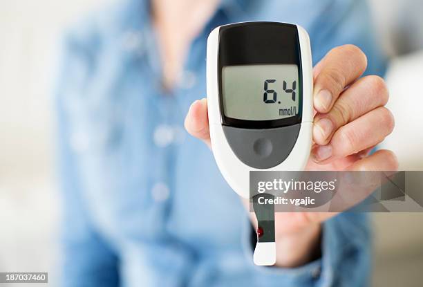 woman showing her glucose level test. - blood sugar test stock pictures, royalty-free photos & images