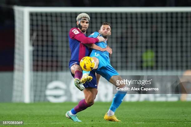 Ronald Araujo of FC Barcelona battles for possession with Leo Baptistao of UD Almeria during the LaLiga EA Sports match between FC Barcelona and UD...