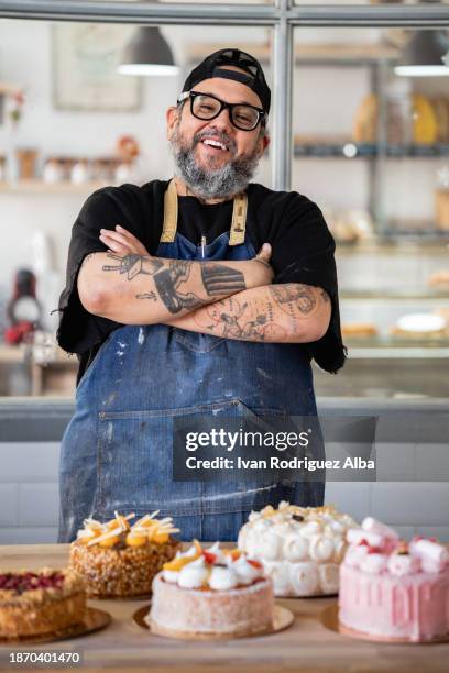 proud baker with an assortment of cakes in a shop - baker occupation stock pictures, royalty-free photos & images