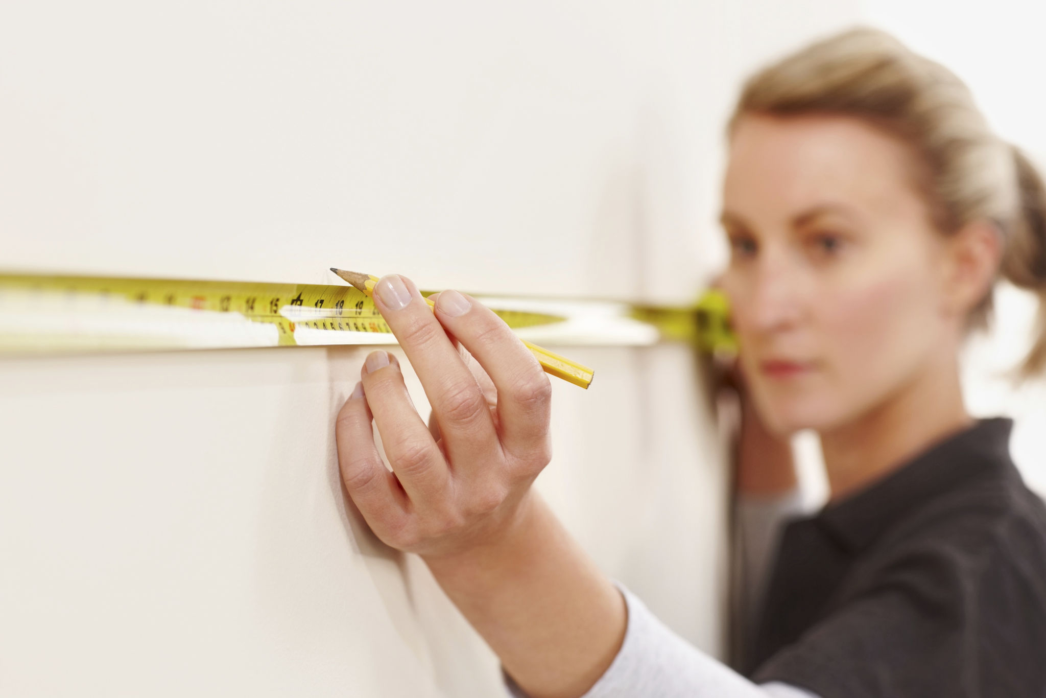 man measuring wall