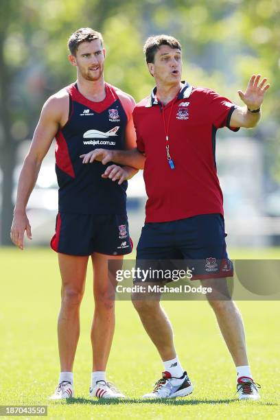 Coach Paul Roos gestures to a player next to Jeremy Howe during a Melbourne Demons AFL training session at Gosch's Paddock on November 6, 2013 in...