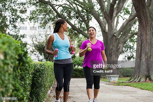 女性のエクササイズの公園 - african american couple walking park ストックフォトと画像