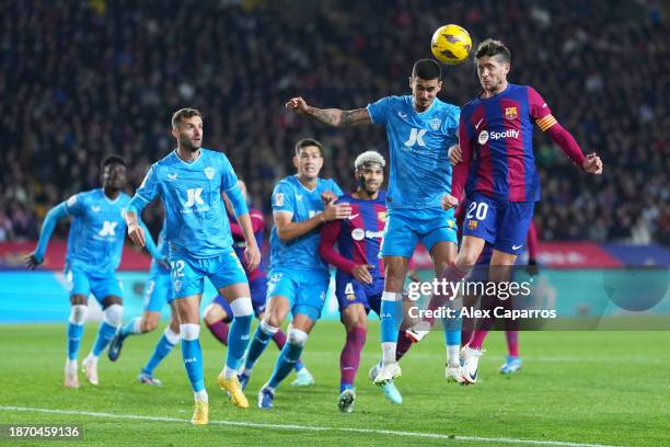 Leo Baptistao of UD Almeria jumps for the ball with Sergi Roberto of FC Barcelona during the LaLiga EA Sports match between FC Barcelona and UD...