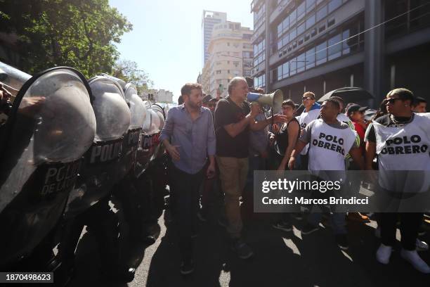 Leader of the Polo Obrero Social Organization Eduardo Beliboni speaks as protesters march along side a line of police officers during a demonstration...