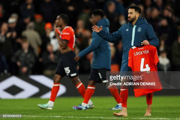 Luton Town's English midfielder Andros Townsend holds the football jersey of Luton Town's Welsh defender Tom Lockyer as he celebrates at the end of...