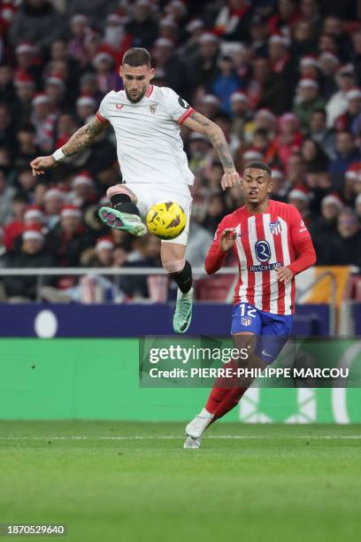 Sevilla's Serbian midfielder Nemanja Gudelj controls the ball next to Atletico Madrid's Brazilian forward Samuel Lino during the Spanish league...