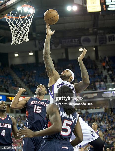 The Sacramento Kings' DeMarcus Cousins, top, scores against the Atlanta Hawks at Sleep Train Arena in Sacramento, California, on Tuesday, November 5,...