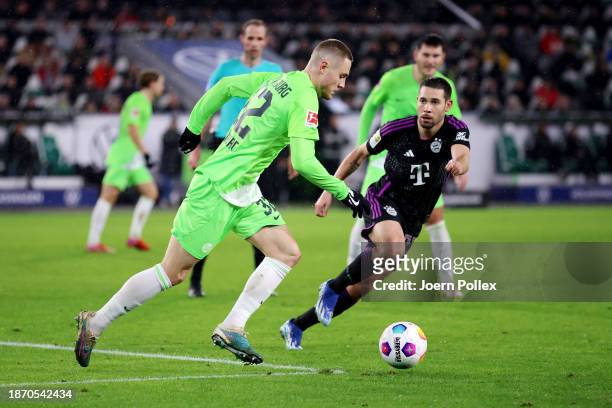 Mattias Svanberg of VfL Wolfsburg is put under pressure by Raphael Guerreiro of Bayern Munich during the Bundesliga match between VfL Wolfsburg and...
