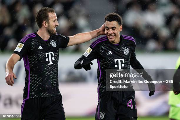 Jamal Musiala of Munich celebrates after scoring his team's first goal with Harry Kane during the Bundesliga match between VfL Wolfsburg and FC...