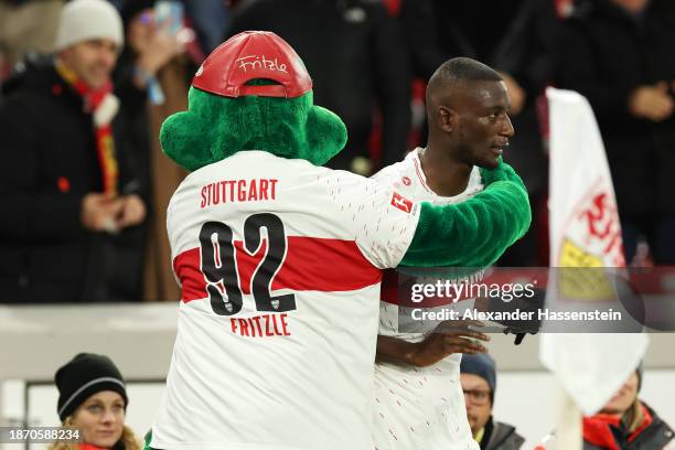 Sehrou Guirassy of VfB Stuttgart celebrates with mascot, Fritzle after scoring their team's second goal during the Bundesliga match between VfB...
