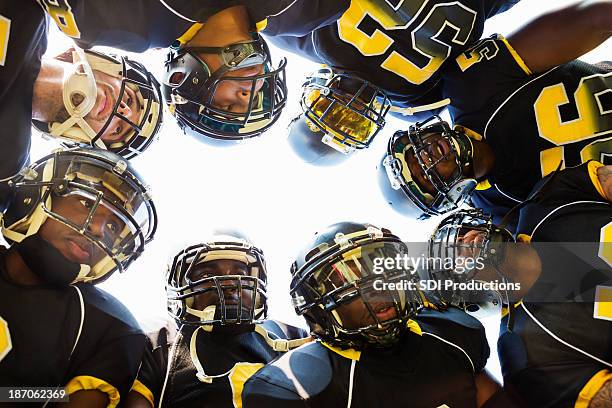 professional football players huddled while in time out during game - american football professional player not soccer stock pictures, royalty-free photos & images