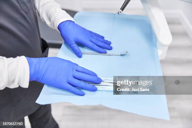 crop dentist preparing equipment for procedure - borracha material imagens e fotografias de stock