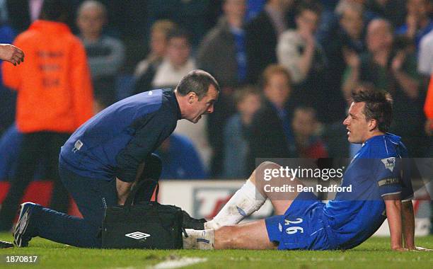 John Terry of Chelsea goes down with an injury at the end of the game during the FA Cup Quarter Final Replay match between Chelsea and Arsenal at...