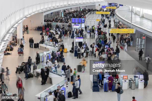 Travelers check-in for their flights for JetBlue flights at John F. Kennedy International Airport on December 23, 2023 in New York, New York.