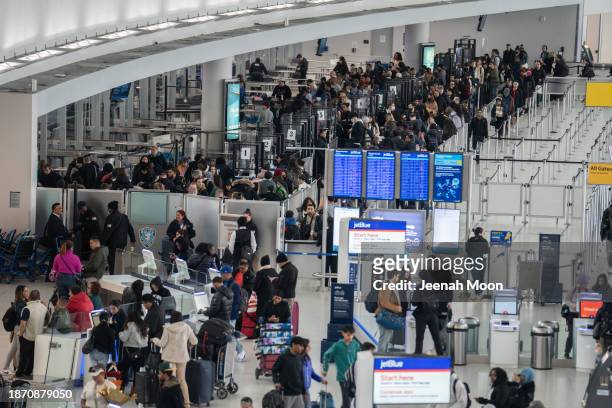 Travelers line up to enter a security checkpoint at John F. Kennedy International Airport on December 23, 2023 in New York, New York.