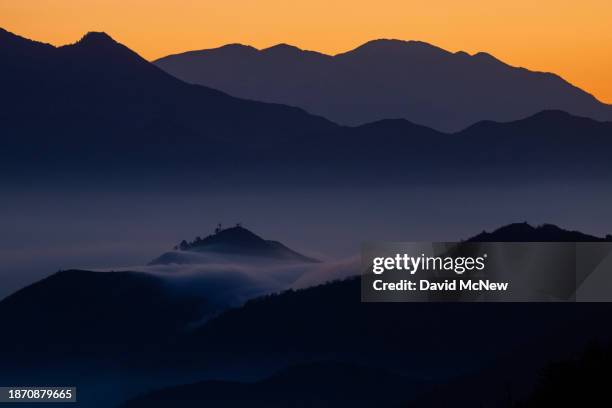 Mist rises in the San Gabriel Mountains as the last of a series of storms that ushered in the start of winter breaks up before sunrise on December 23...