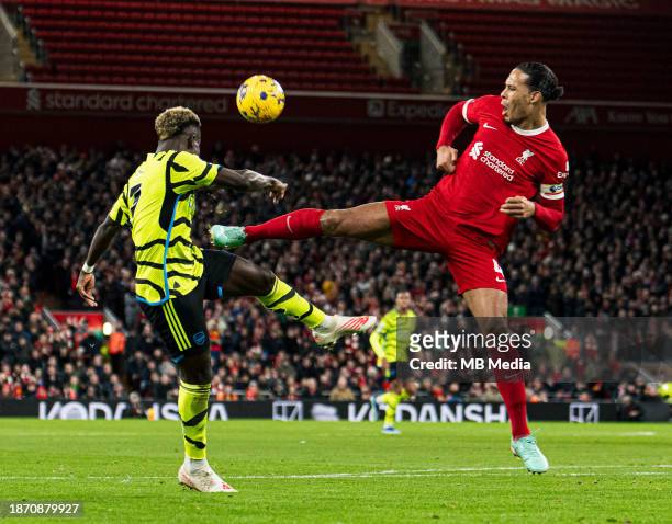 Virgil van Dijk of Liverpool battles for the ball with Bukayo Saka of Arsenal during the Premier League match between Liverpool FC and Arsenal FC at...