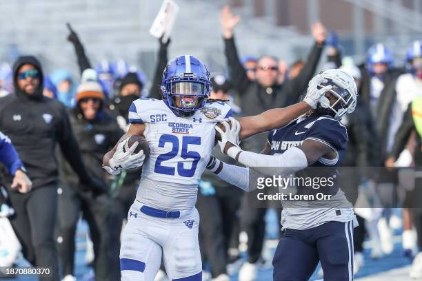 Running back Freddie Brock of the Georgia State Panthers stiff-arms safety Ike Larsen of the Utah State Aggies during the first half of the Famous...