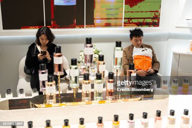 Shoppers use their smartphones inside a store at Harbour City shopping mall in the Tsim Sha Tsui area of Hong Kong, China, on Saturday, Dec. 23,...
