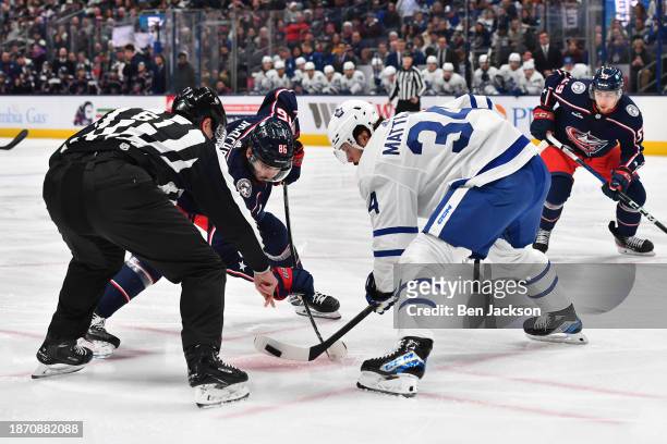 Auston Matthews of the Toronto Maple Leafs wins the puck in a face-off against Kirill Marchenko of the Columbus Blue Jackets during the first period...
