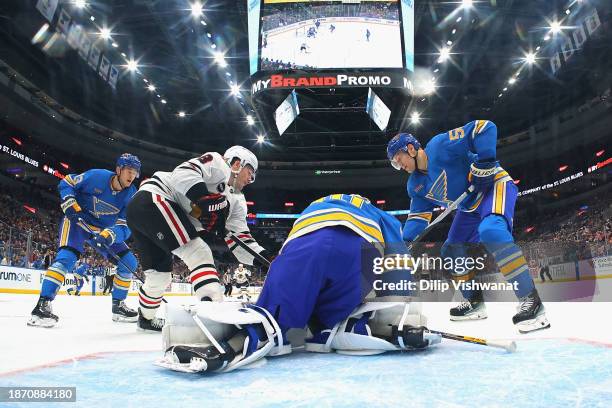 Jordan Binnington and Colton Parayko both of the St. Louis Blues defend against Ryan Donato of the Chicago Blackhawks in the first period at...