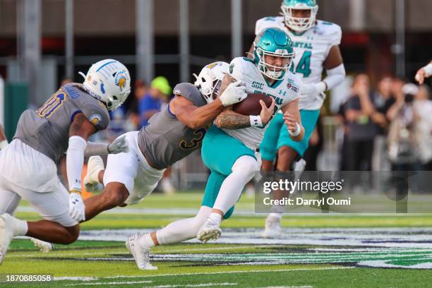 Ethan Vasko of the Coastal Carolina Chanticleers is brought down by Tre Smith of the San Jose State Spartans during the first half of the Hawaii Bowl...