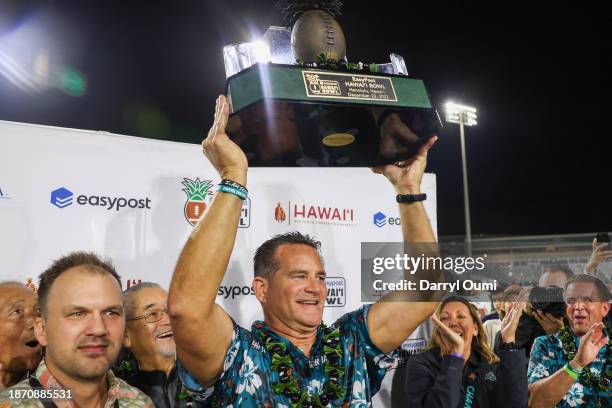 Head coach Tim Beck of the Coastal Carolina Chanticleers hoists the championship trophy after winning the Hawaii Bowl at Clarence T.C. Ching...