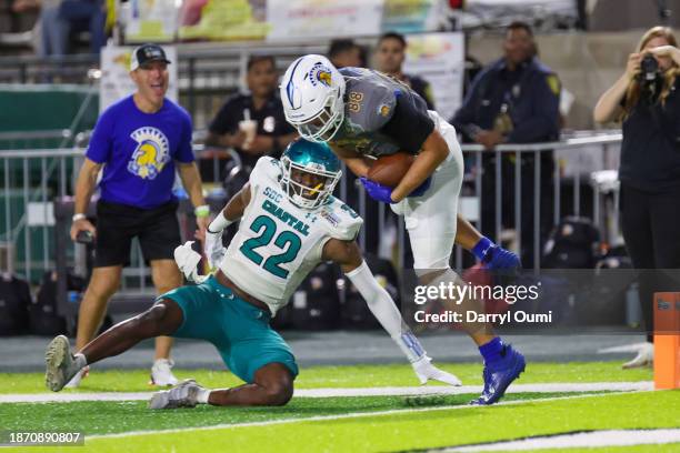 Sam Olson of the San Jose State Spartans fights to stay inbounds after making a catch as he crosses the goal line ahead of Clayton Isbell of the...