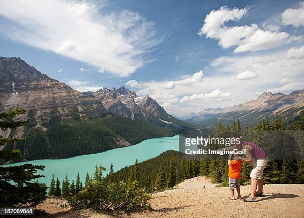 mother and child taking pictures at beautiful mountain lake - peyto lake stock pictures, royalty-free photos & images