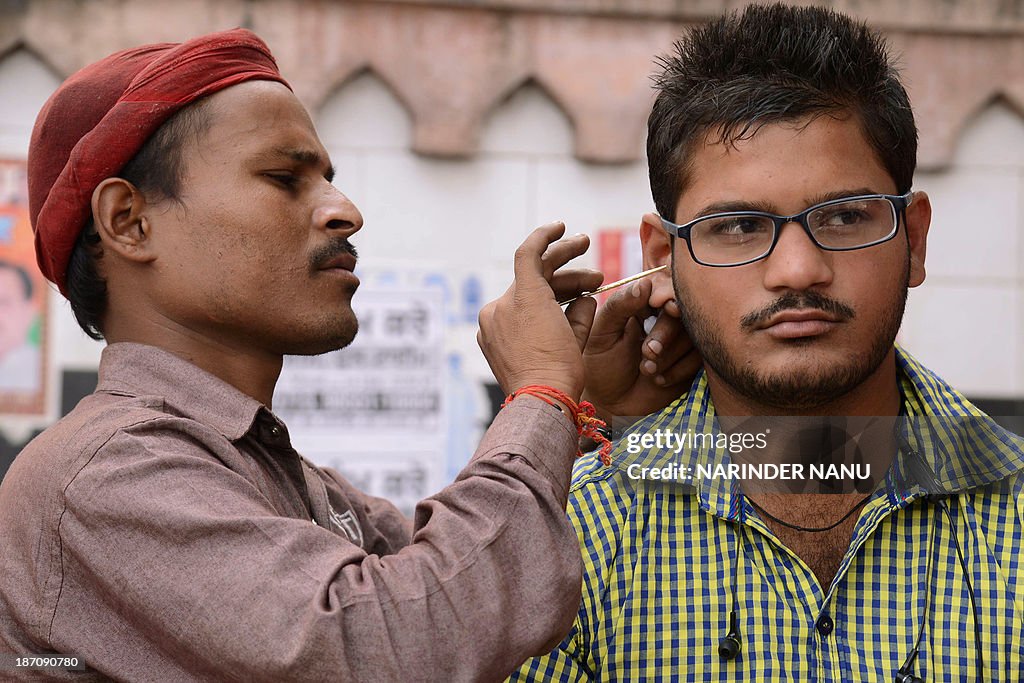 An Indian traditional ear cleaner Vinod cleans the ears of a youth at ...