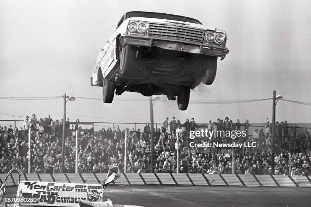 Canadian stunt driver Ken Carter is at the wheel as his Chevy stock car lifts in the air during a record breaking jump of 107-feet at the Islip...