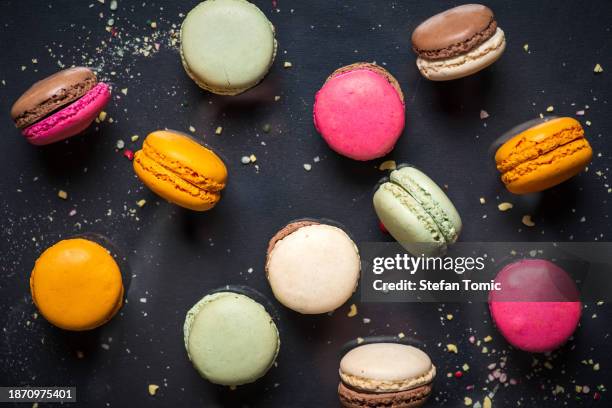 macarons français multicolores sur fond sombre - macaron photos et images de collection