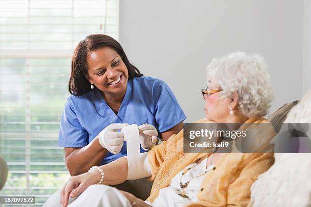 mujer senior con trabajador de asistencia sanitaria - venda fotografías e imágenes de stock