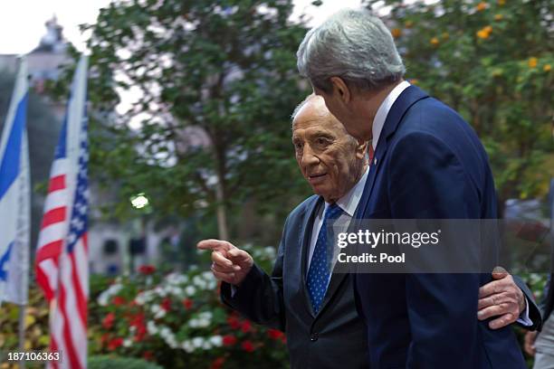 Israeli President Shimon Peres puts his arm around U.S. Secretary of State John Kerry's waist as the U.S. Diplomat arrives at the Peres' residence...