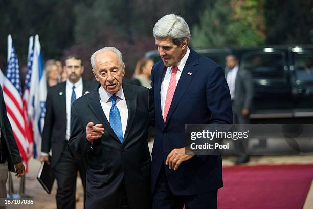 Israeli President Shimon Peres escorts U.S. Secretary of State John Kerry as the U.S. Diplomat arrives at the Peres' residence November 6, 2013 in...