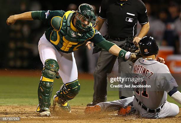 Victor Martinez of the Detroit Tigers is tagged out at home by Stephen Vogt of the Oakland Athletics during Game One of the American League Division...