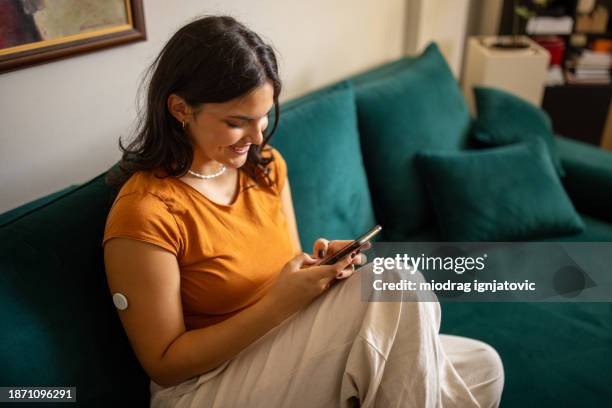 young woman using mobile - continuous glucose monitor stock pictures, royalty-free photos & images