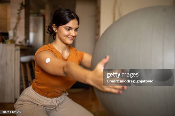 young woman exercising at home - continuous glucose monitor stock pictures, royalty-free photos & images