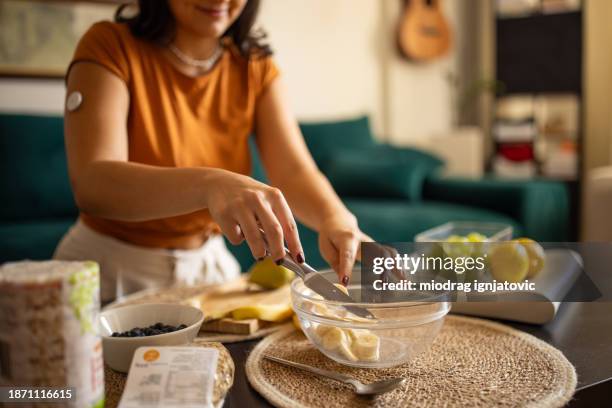 young woman preparing a healthy meal - continuous glucose monitor stock pictures, royalty-free photos & images