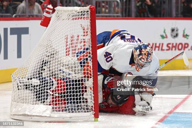 Tom Wilson of the Washington Capitals collides with goalie Semyon Varlamov of the New York Islanders during the second period at Capital One Arena on...