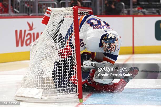 Tom Wilson of the Washington Capitals collides with goalie Semyon Varlamov of the New York Islanders during the second period at Capital One Arena on...