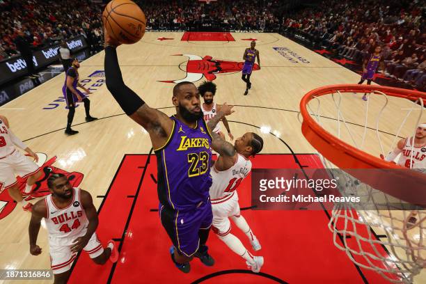 LeBron James of the Los Angeles Lakers dunks over DeMar DeRozan of the Chicago Bulls during the first half at the United Center on December 20, 2023...