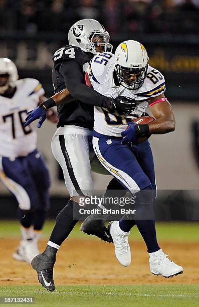 Tight end Antonio Gates of the San Diego Chargers wrestles for extra yards after a catch against linebacker Kevin Burnett of the Oakland Raiders on...