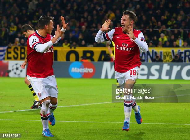 Aaron Ramsey of Arsenal celebrates scoring their first goal with Mesut Oezil of Arsenal during the UEFA Champions League Group F match between...