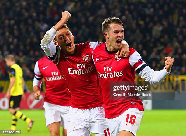 Aaron Ramsey of Arsenal celebrates scoring their first goal with Mesut Oezil of Arsenal during the UEFA Champions League Group F match between...